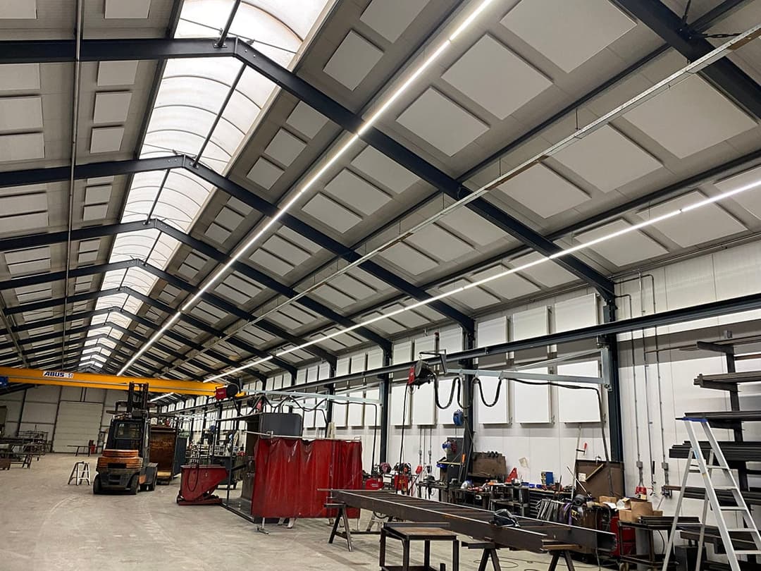In deze fabriekshal van Vernooy Constructies zijn EASYindustry plafondpanelen geplaatst. De panelen verbeteren de akoestiek en zorgen voor een stillere en prettigere werkomgeving.